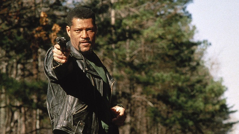 Laurence Fishburne as Charles Piper holding a gun
