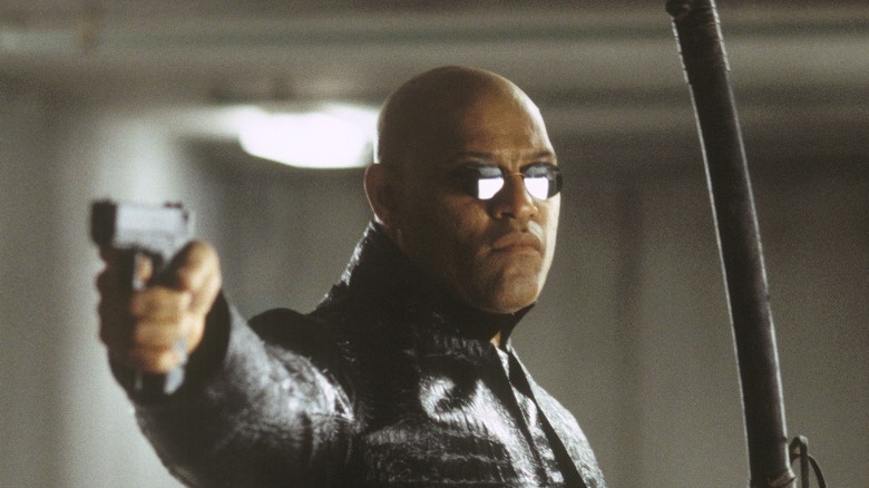 Laurence Fishburne as Morpheus holding sword and gun