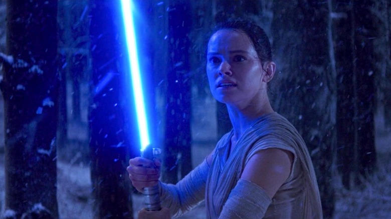 Rey with the lightsaber for the first time