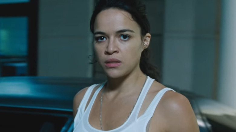 Letty Ortiz stands in front of a car looking concerned