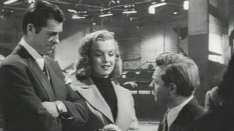 Monroe talking to two men 
