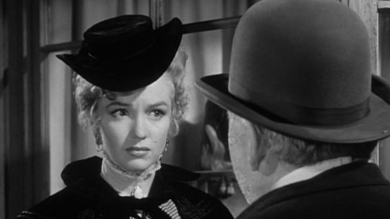 Monroe wearing black dress and hat 