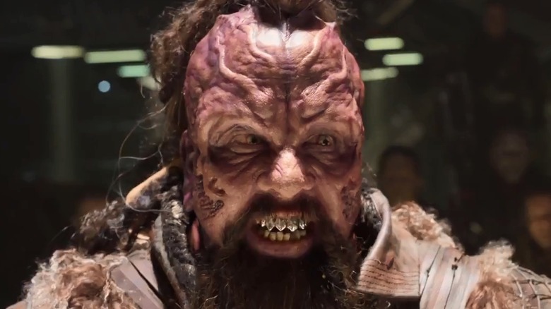 Taserface grins and shows off his metal teeth