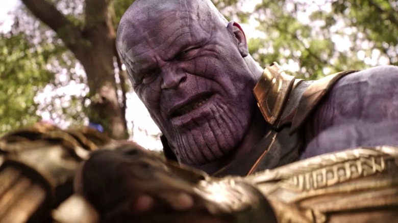 Thanos looking down at the Infinity Gauntlet