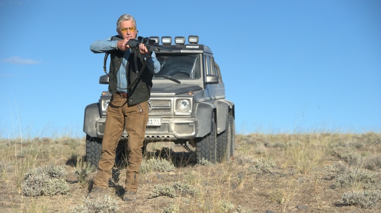 Michael Douglas aiming down rifle barrel