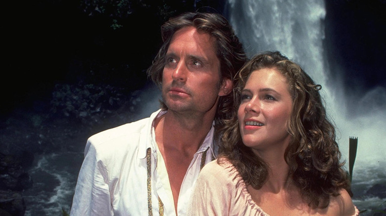 Michael Douglas and Kathleen Turner in front of a waterfall