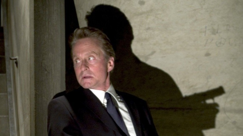 Michael Douglas taking cover behind a corner