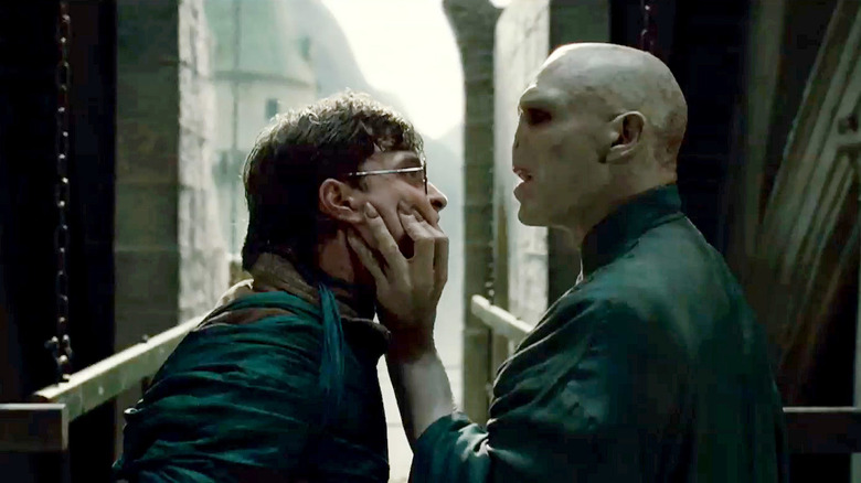 Ralph Fiennes squeezes Daniel Radcliffe's face