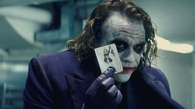 Joker holds up a playing card