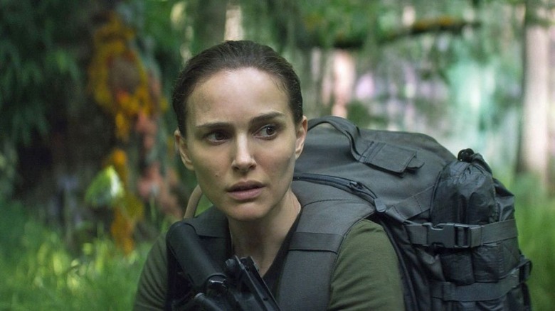 Portman holding rifle in the jungle