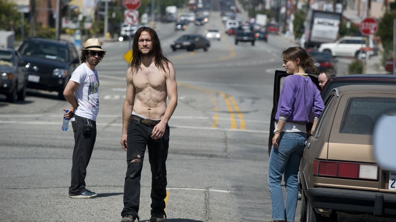 Gordon-Levitt walking shirtless down the street past Portman