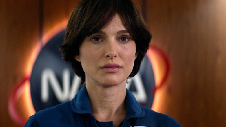 Portman standing in front of NASA logo