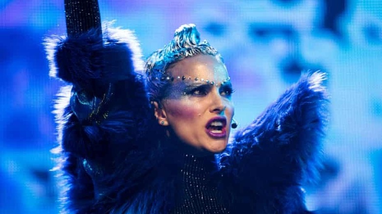 Portman performing on stage in blue feathers