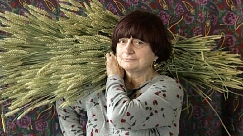 Agnes Varda carries wheat