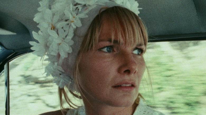 Wanda, wearing a flower headdress in a car