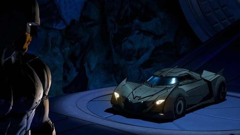 Batman looking at the Batmobile