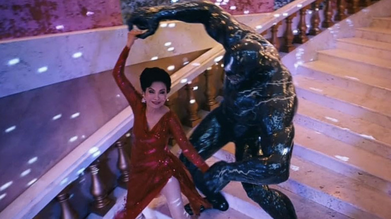 Venom and Mrs. Chen dance down marble stairs in "Venom: The Last Dance" (2024)