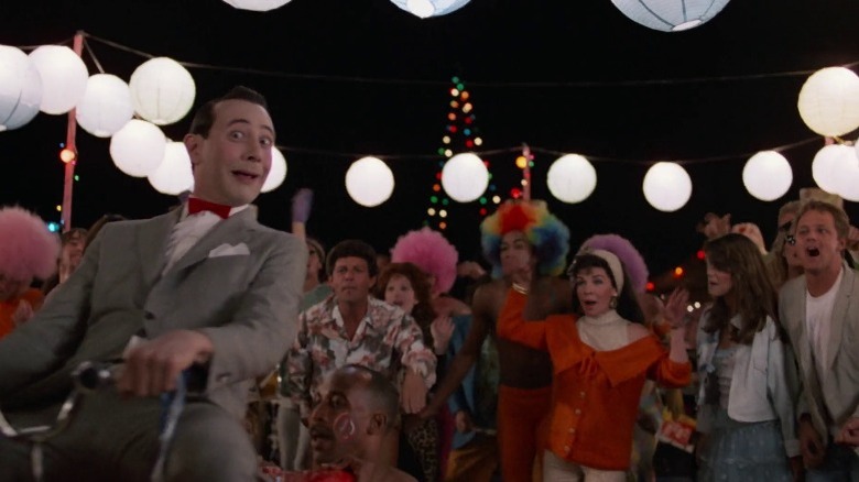 Pee-wee Herman gets carried on a surfboard