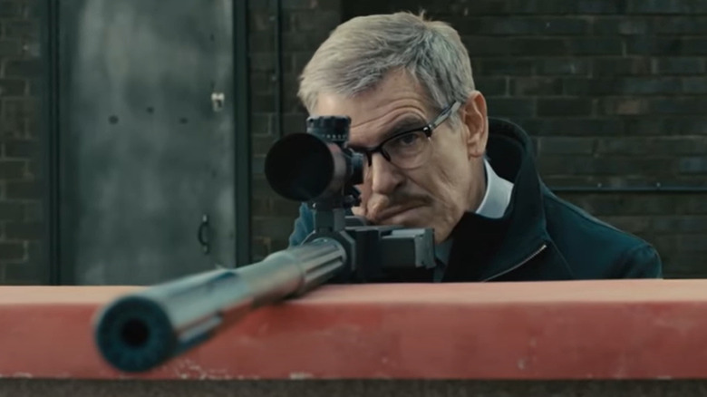 Pierce Brosnan holding sniper rifle