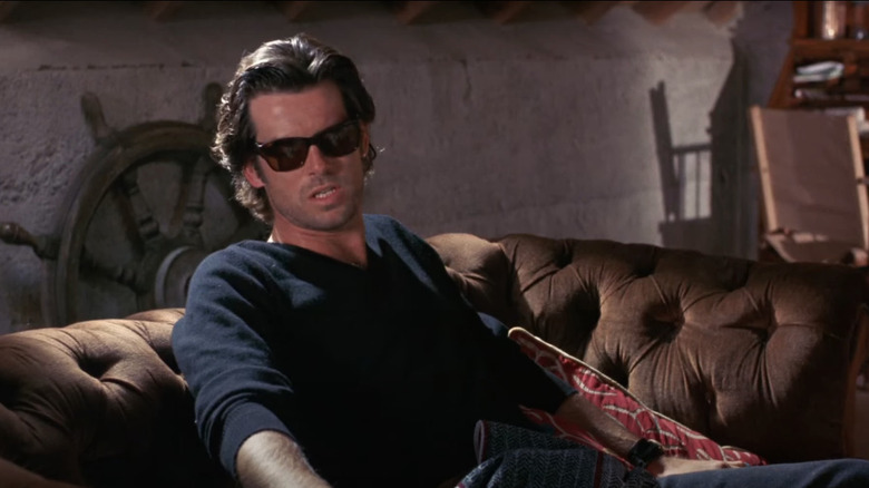 Pierce Brosnan on a couch wearing sunglasses