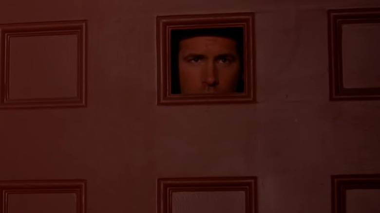 Ryan Reynolds looks through hole in door