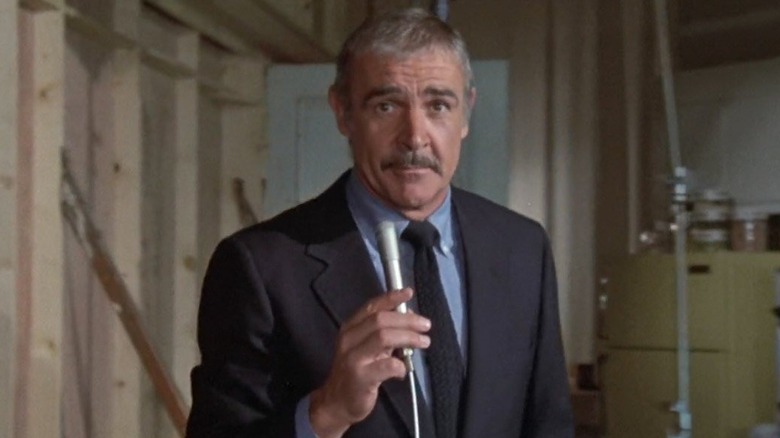 Connery holds a microphone