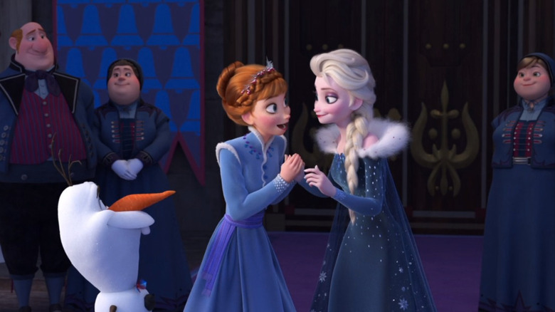 Anna and Elsa smiling in blue Christmas dresses