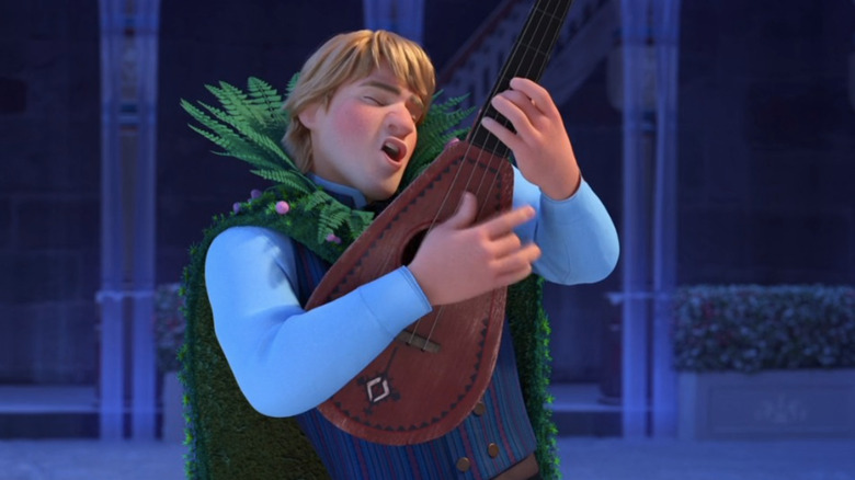 Kristoff singing with guitar and traditional cape of leaves