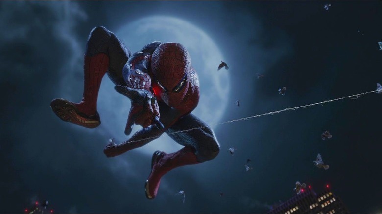 Spider-Man swings in front of moon