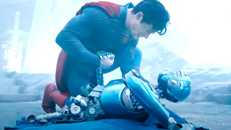 Superman holding a damaged robot in Superman (2025)