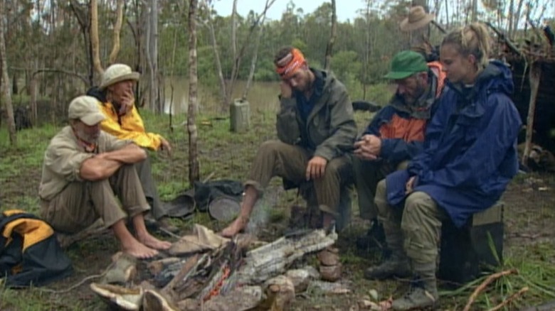 Survivor contestants around fire