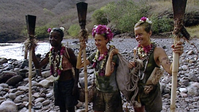 Survivor contestants holding torches