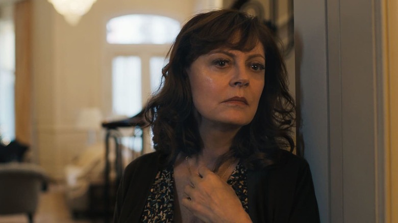 Susan Sarandon frowns leaning against doorway