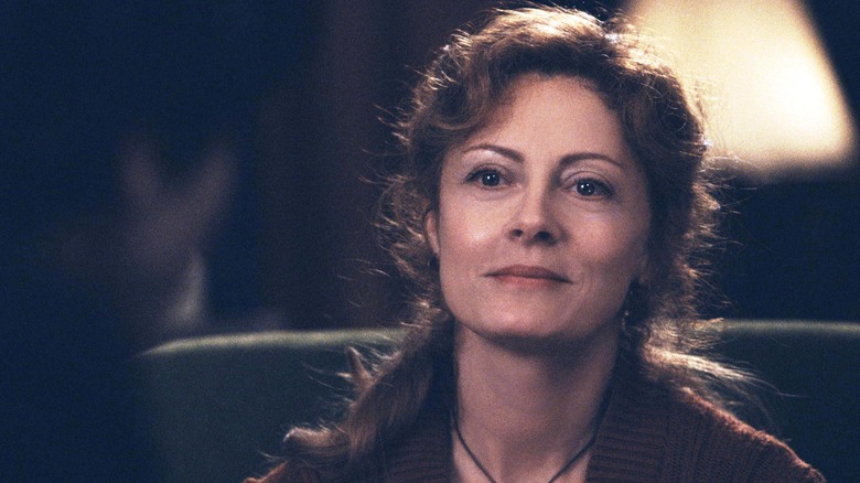 Susan Sarandon smiles looking at man