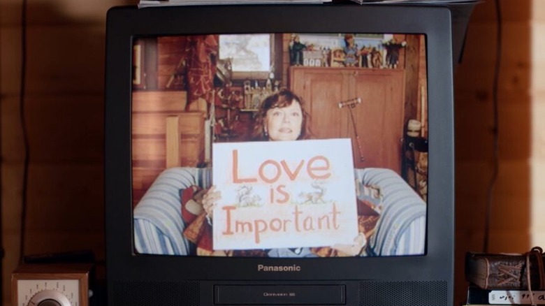 Susan Sarandon holds up a sign on a television