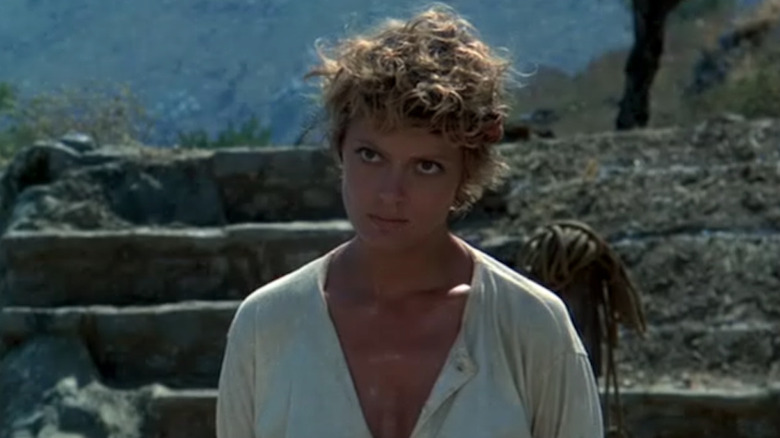 Susan Sarandon looks up glaring in front of rocks