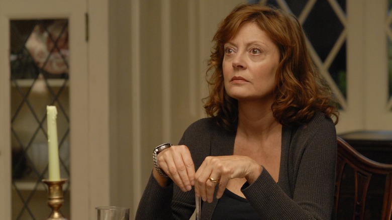 Susan Sarandon looks up holding fork at table