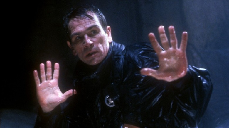 Tommy Lee Jones holds hands up in The Fugitive