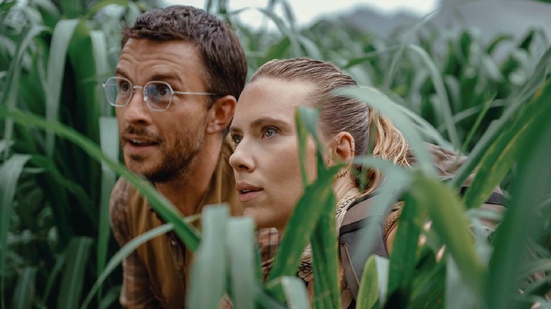 Dr. Henry Loomis and Zara Bennett hiding in the grass