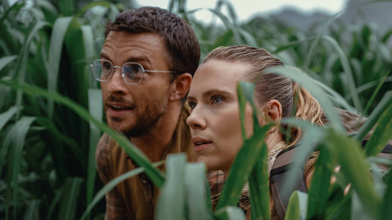 Dr. Henry Loomis and Zora Bennett hiding in tall grass