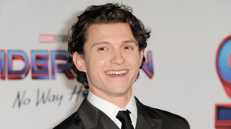 Tom Holland smiling at a press event in 2021