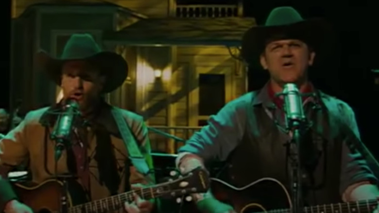 Woody Harrelson and John C. Reilly playing guitars