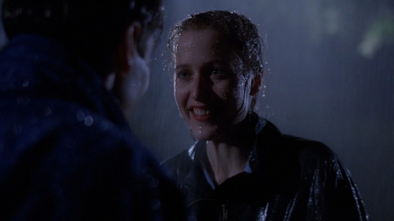 Scully smiling at Mulder in the rain 