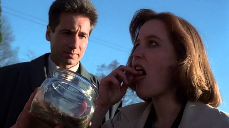 Scully eating something out of a jar 