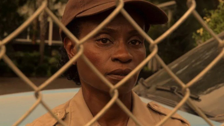 Sherriff Susan Peterkin peers through a fence in "Outer Banks"