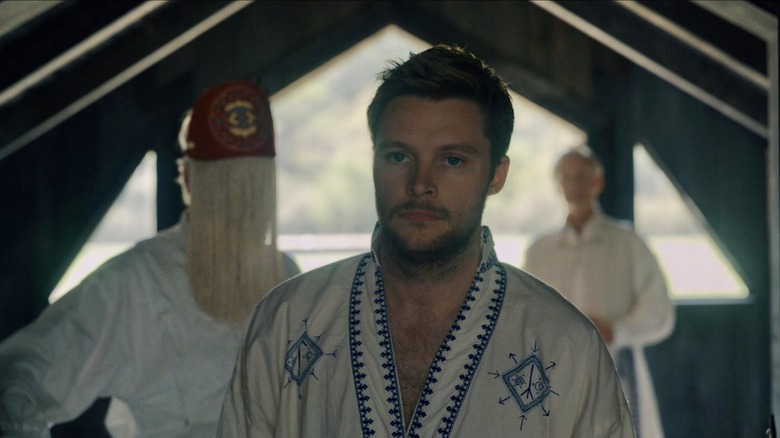 Christian looks serious in barn