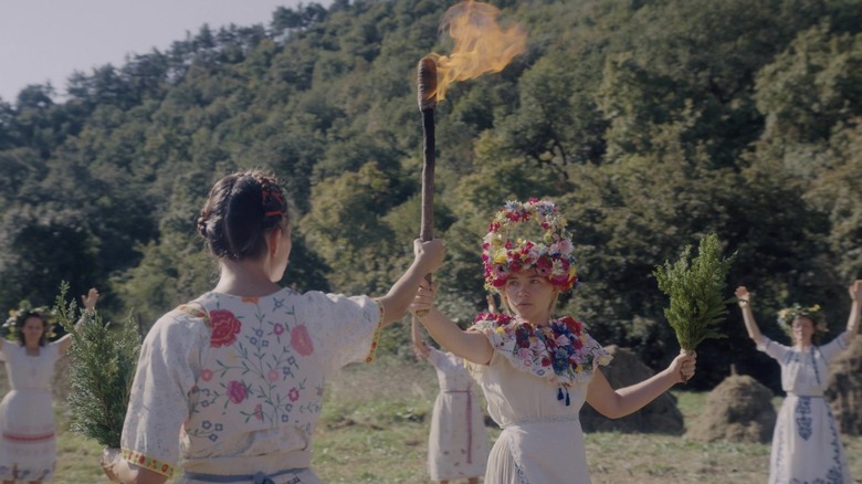 Dani holds torch with other woman