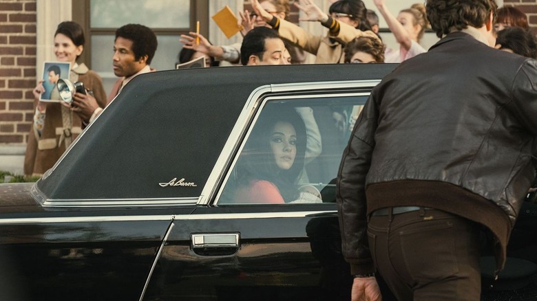 Priscilla in car surrounded by fans