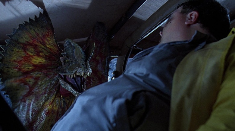 A dilophosaurus spreads its frills at a nervous Nedry