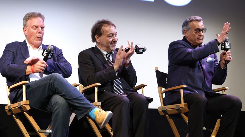 Rob Tapert, Sam Raimi, and Bruce Campbell sitting in folding chairs